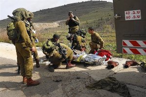 Israeli soldiers evacuate their comrade who was wounded during an explosion near the Druze village of Majdal Shams in the Golan Heights