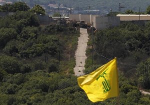 An Israeli military outpost as seen from South Lebanon, where a Hezbollah flag flutters